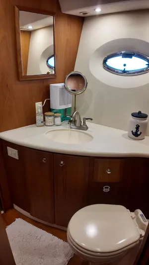  Yacht Photos Pics 2002 Silverton 410 Sport Bridge bathroom with sink, mirror, and porthole window.