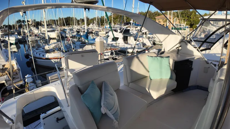  Yacht Photos Pics 2002 Silverton 410 Sport Bridge yacht interior with marina view, featuring plush seating and cushions.
