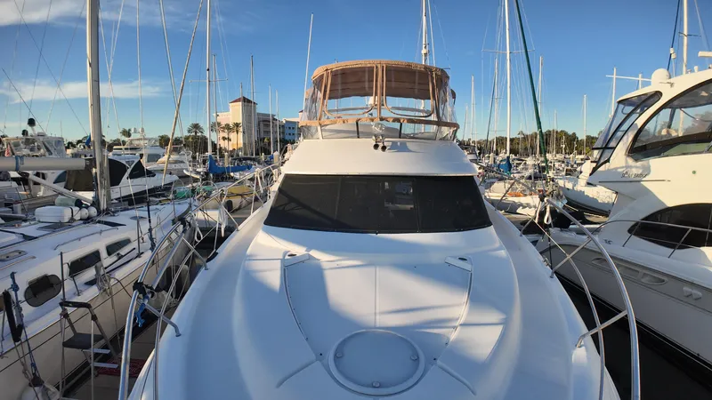  Yacht Photos Pics 2002 Silverton 410 Sport Bridge yacht docked in a marina, surrounded by other boats.