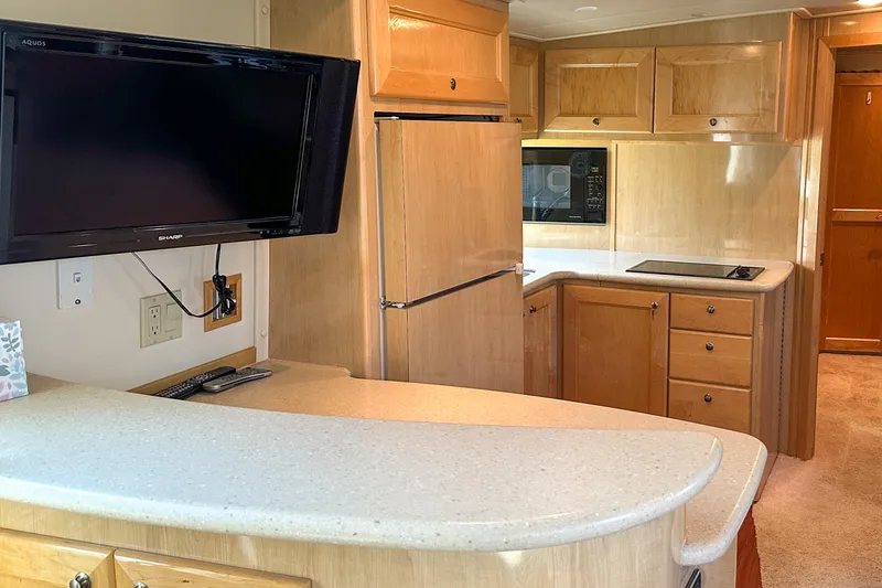  Yacht Photos Pics Interior of 2012 Bluewater 5200 Custom Series Yacht with kitchen and TV setup.