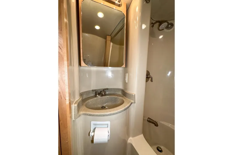  Yacht Photos Pics Compact bathroom in 2012 Bluewater 5200 Custom Series Yacht with sink, mirror, and shower.