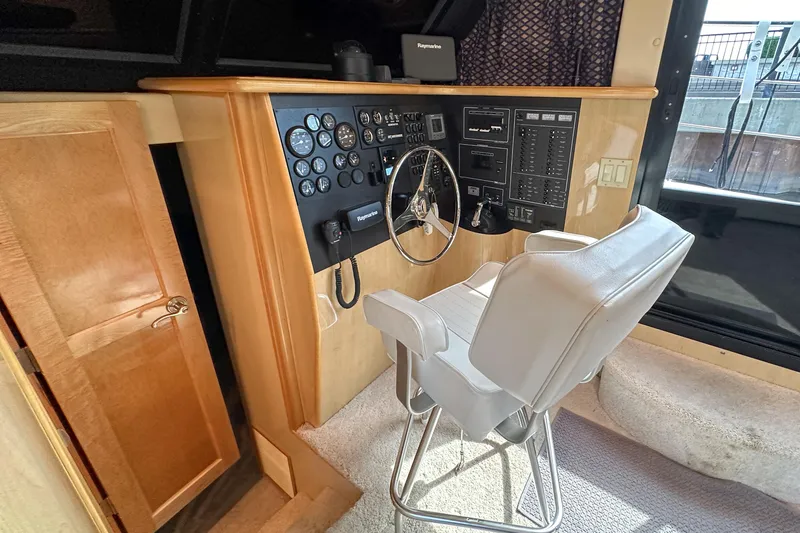  Yacht Photos Pics Interior helm of 2012 Bluewater 5200 Custom Series Yacht with control panel and captain's chair.