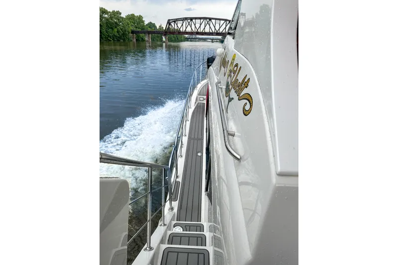  Yacht Photos Pics 2012 Bluewater 5200 yacht cruising on a river near a bridge.