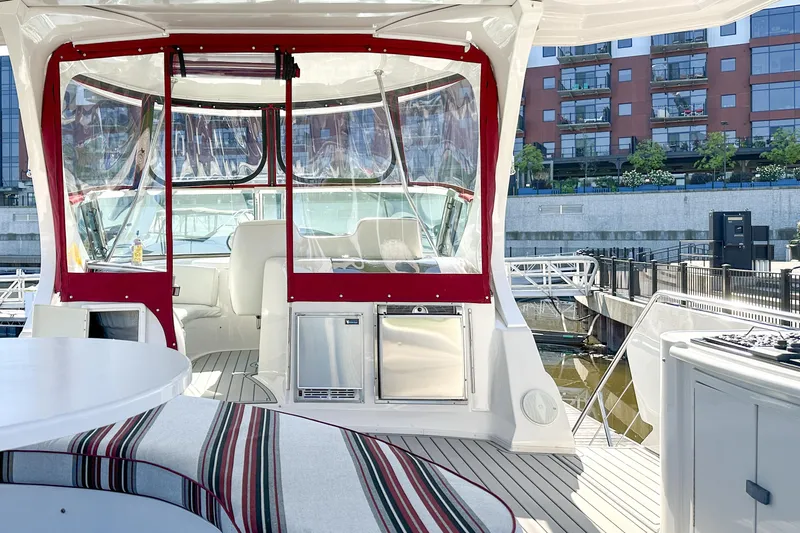  Yacht Photos Pics Luxurious 2012 Bluewater 5200 yacht interior with red accents, docked near modern buildings.