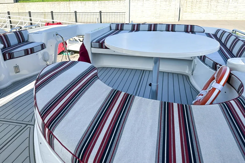  Yacht Photos Pics Luxurious 2012 Bluewater 5200 yacht with striped seating and round table on deck.