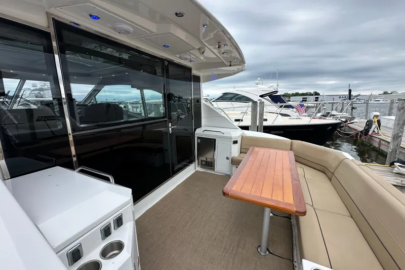 Sexy B'yacht-ch Yacht Photos Pics 2013 Cruisers Yachts 45 Cantius with outdoor seating and table, docked at marina.