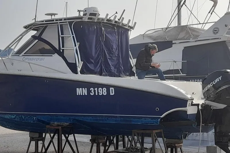  Yacht Photos Pics 2009 Fountain 33 Sportfish Cruiser on stands, person working on deck.