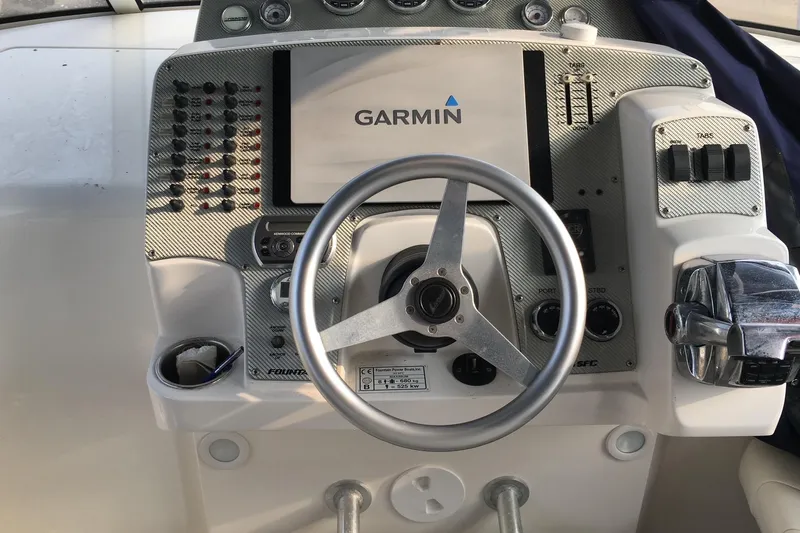  Yacht Photos Pics 2009 Fountain 33 Sportfish Cruiser helm with Garmin navigation system and steering wheel.