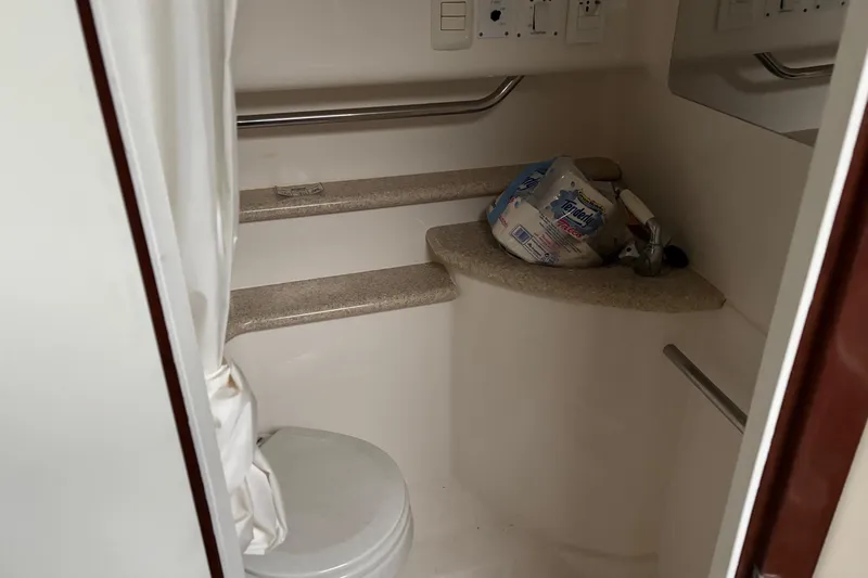  Yacht Photos Pics 2009 Fountain 33 Sportfish Cruiser bathroom with toilet, sink, and storage shelves.