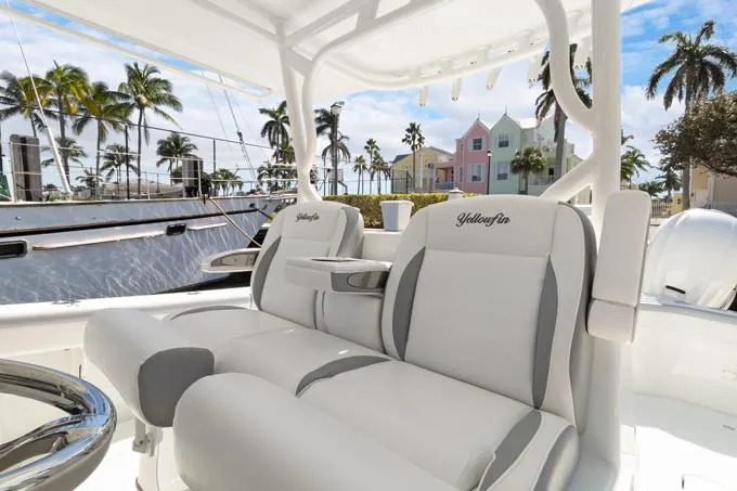 Seas The Day Yacht Photos Pics 2020 Yellowfin 39 Center Console boat with luxurious seating, palm trees, and colorful buildings in the background.