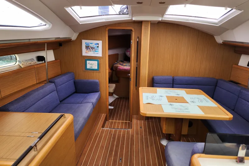 Vilia Yacht Photos Pics Interior of 2010 Jeanneau Sun Odyssey 45 DS sailboat with cozy seating and wooden finishes.
