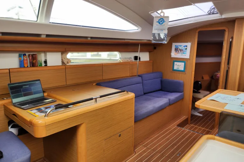 Vilia Yacht Photos Pics Interior of 2010 Jeanneau Sun Odyssey 45 DS yacht with cozy seating and wooden finishes.