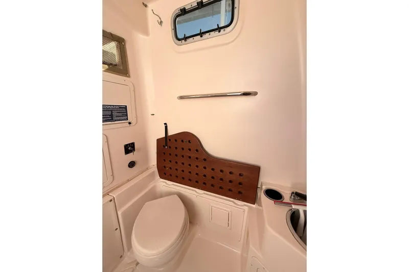 Repowered Yacht Photos Pics 2011 Grady-White Canyon 336 boat bathroom interior with toilet and porthole window.