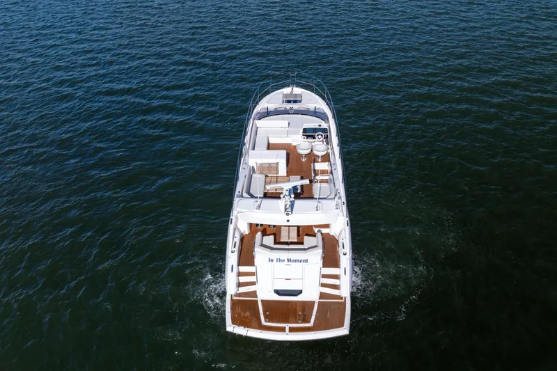 In The Moment Yacht Photos Pics 2018 Sunseeker Manhattan 52 yacht cruising on open water, aerial view.