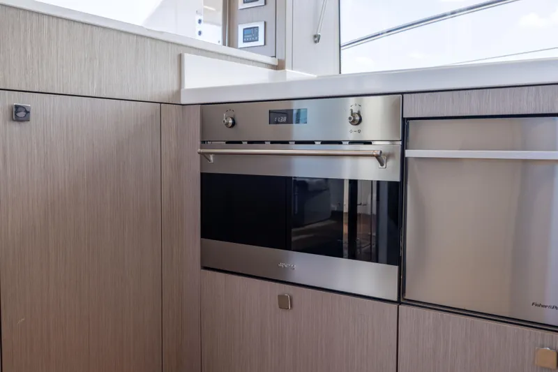 In The Moment Yacht Photos Pics Modern kitchen interior on 2018 Sunseeker Manhattan 52 yacht, featuring sleek appliances.