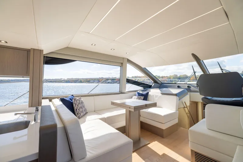In The Moment Yacht Photos Pics Luxurious interior of 2018 Sunseeker Manhattan 52 yacht with elegant seating and scenic water view.