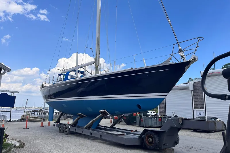  Yacht Photos Pics Sailboat Nautor Swan 61, 1990 model, on trailer at marina under blue sky.