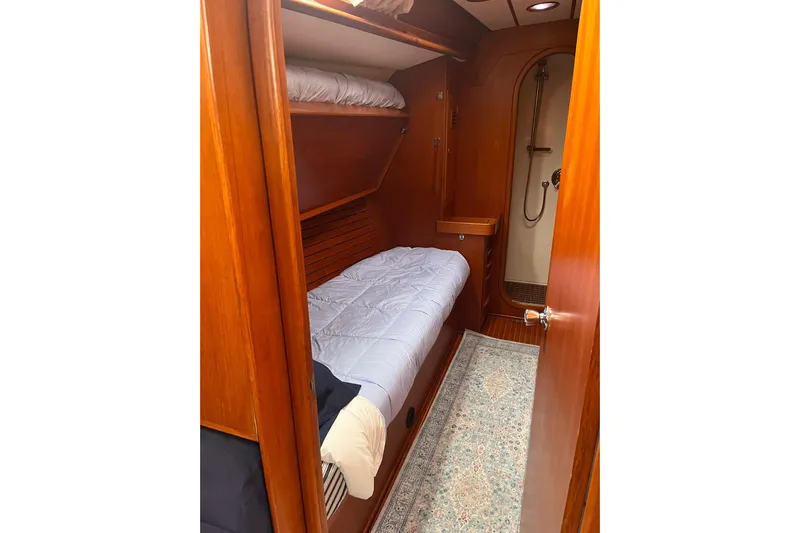  Yacht Photos Pics Cozy cabin interior of 1990 Nautor Swan 61 yacht with wooden finish and bunk bed.