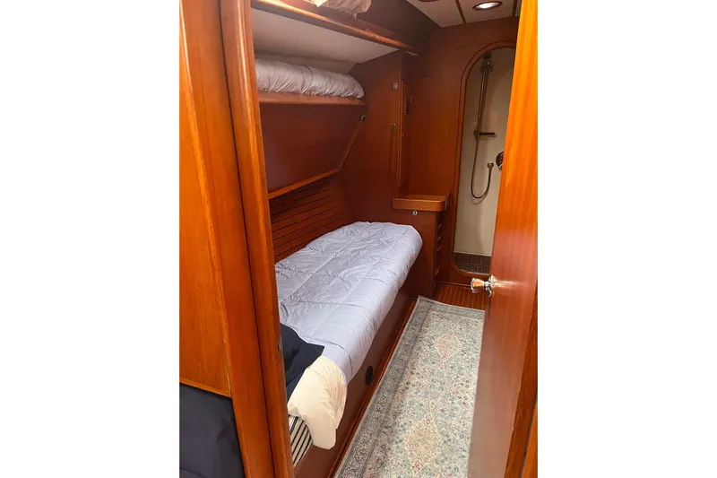  Yacht Photos Pics Cozy cabin interior of 1990 Nautor Swan 61 yacht with wooden finish and bunk beds.