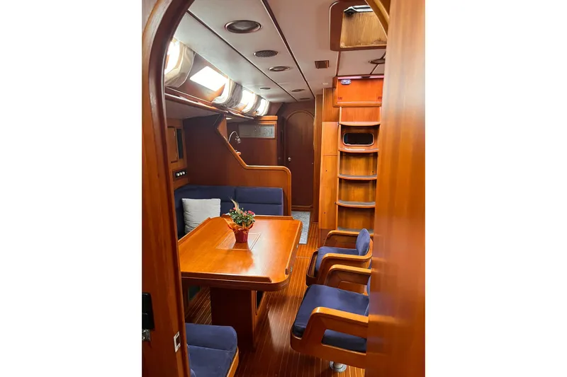  Yacht Photos Pics Interior of 1990 Nautor Swan 61 yacht with wooden furnishings and blue seating.