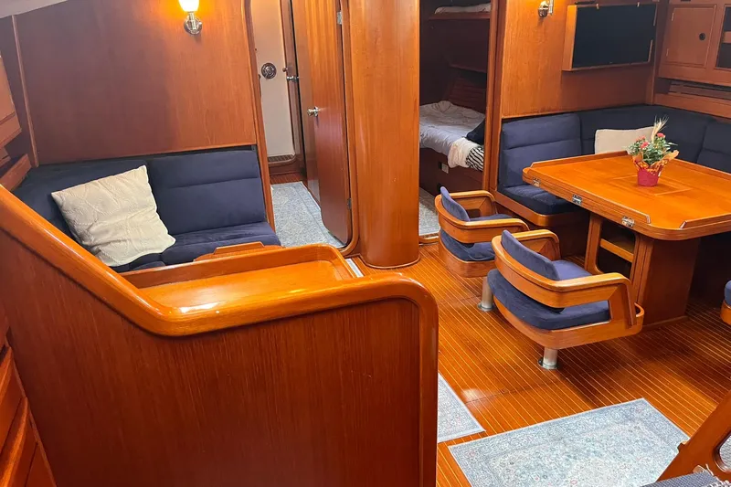  Yacht Photos Pics Luxurious 1990 Nautor Swan 61 yacht interior with wooden furnishings and blue seating.