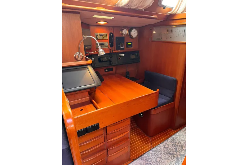  Yacht Photos Pics Interior of 1990 Nautor Swan 61 yacht with wooden navigation station and seating area.