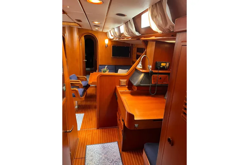  Yacht Photos Pics Luxurious interior of 1990 Nautor Swan 61 yacht with wooden furnishings and seating area.