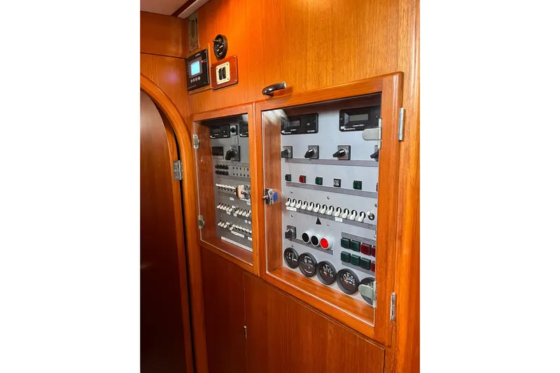  Yacht Photos Pics Control panel on a 1990 Nautor Swan 61 yacht, featuring wooden cabinetry and various switches.