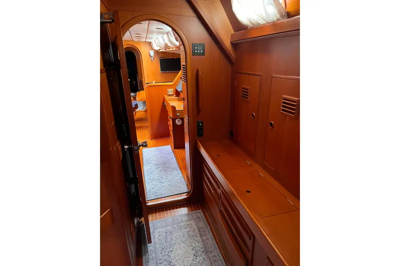  Yacht Photos Pics Interior of 1990 Nautor Swan 61 yacht, featuring wooden cabinetry and cozy hallway.