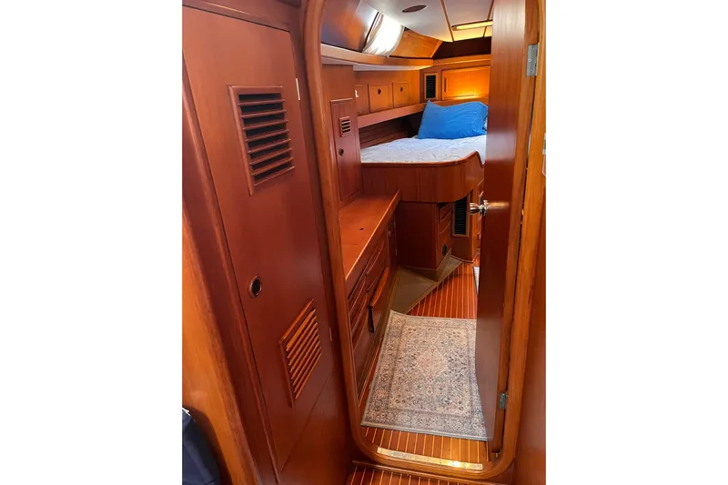  Yacht Photos Pics Luxurious wooden cabin interior of 1990 Nautor Swan 61 yacht with cozy bed and elegant decor.