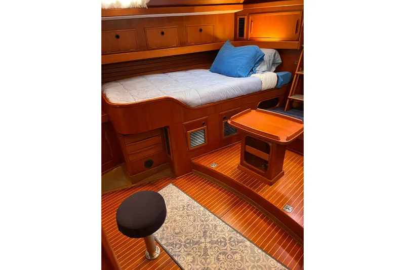  Yacht Photos Pics Luxurious 1990 Nautor Swan 61 yacht cabin with wooden interior and cozy bedding.