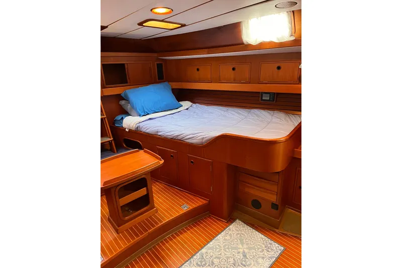  Yacht Photos Pics Luxurious wooden cabin interior of 1990 Nautor Swan 61 yacht with cozy bed and storage.