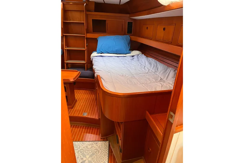  Yacht Photos Pics Cozy cabin interior of 1990 Nautor Swan 61 yacht with wooden finish and bed.