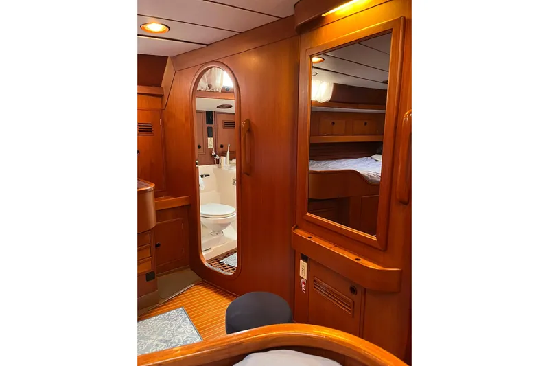  Yacht Photos Pics Luxurious wooden interior of 1990 Nautor Swan 61 yacht, featuring a cozy cabin and bathroom.