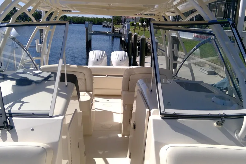  Yacht Photos Pics 2023 Grady-White Freedom 285 boat interior with dual engines, docked by a serene waterfront.