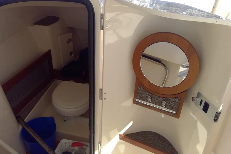  Yacht Photos Pics 2023 Grady-White Freedom 285 boat interior with toilet and mirror.