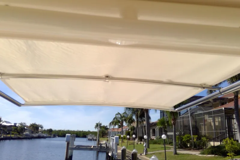  Yacht Photos Pics 2023 Grady-White Freedom 285 boat canopy with waterfront view and palm trees.