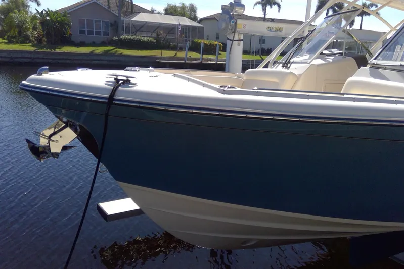  Yacht Photos Pics 2023 Grady-White Freedom 285 boat docked on calm water, showcasing sleek design.