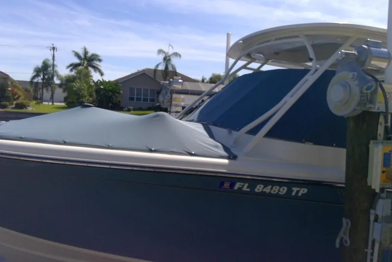  Yacht Photos Pics 2023 Grady-White Freedom 285 boat docked, covered, with palm trees in the background.