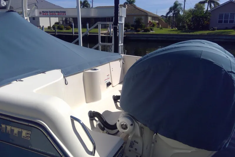  Yacht Photos Pics 2023 Grady-White Freedom 285 boat with covered seating and engine, docked near waterfront homes.