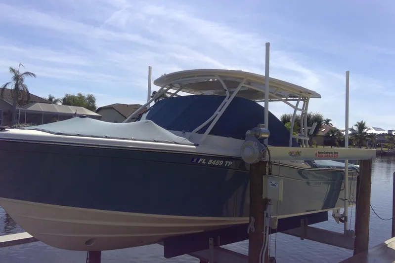  Yacht Photos Pics 2023 Grady-White Freedom 285 boat docked on a lift under a clear sky.
