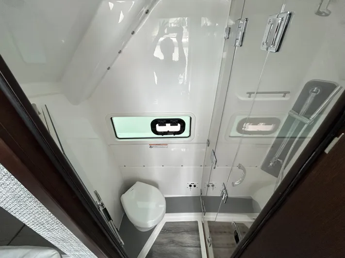  Yacht Photos Pics 2023 Everglades 455 boat bathroom with modern fixtures and compact design.