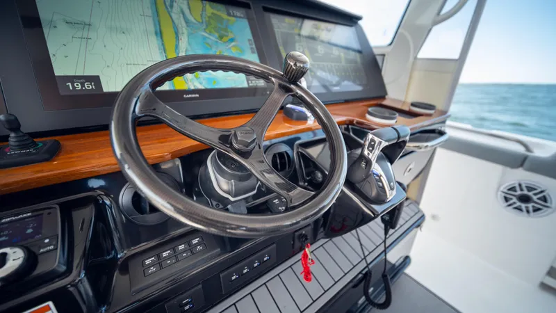  Yacht Photos Pics Steering wheel and controls of 2023 Everglades 455 boat with navigation screens.