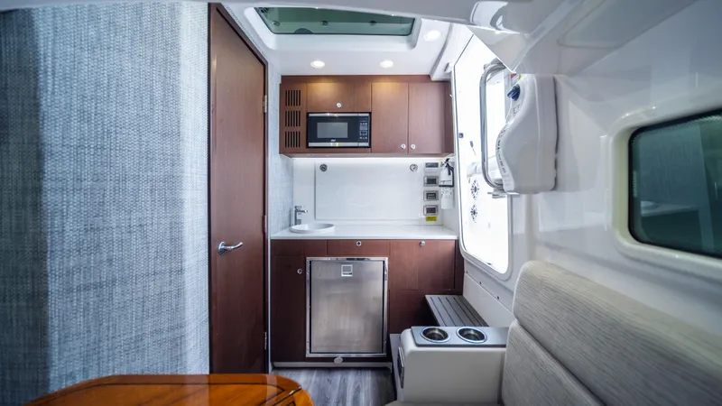  Yacht Photos Pics Compact kitchen area in 2023 Everglades 455 boat with modern amenities.
