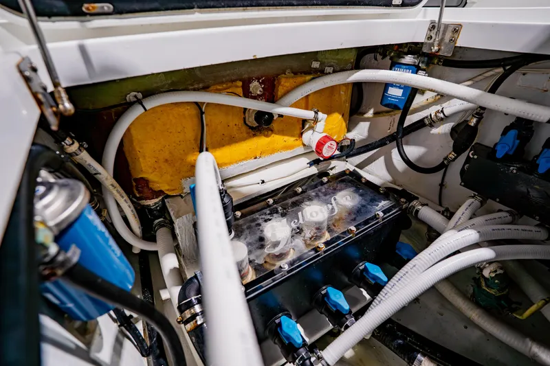  Yacht Photos Pics Engine compartment of a 2012 Yellowfin 39 Offshore boat, showcasing hoses and components.