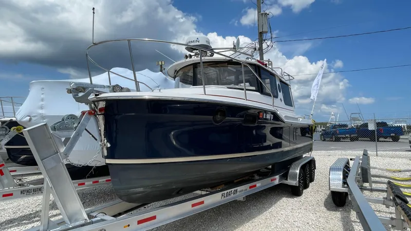  Yacht Photos Pics 2022 Ranger Tugs R-25 boat on trailer under a cloudy sky.