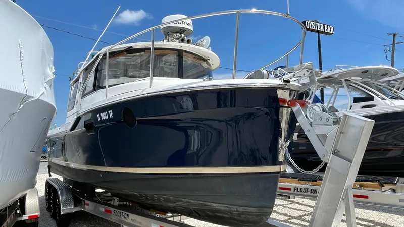  Yacht Photos Pics 2022 Ranger Tugs R-25 boat on trailer, blue hull, docked outdoors.