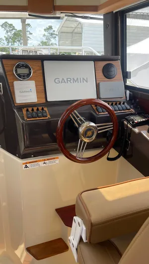  Yacht Photos Pics 2022 Ranger Tugs R-25 helm with Garmin navigation system and wood-accented steering wheel.