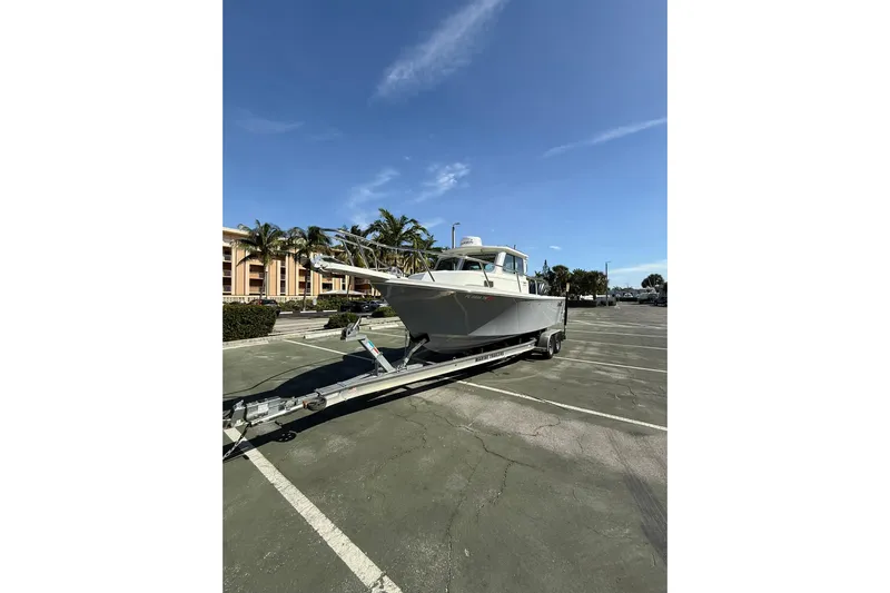  Yacht Photos Pics 2023 Parker 2320 Sport Cabin boat on trailer in sunny parking lot.