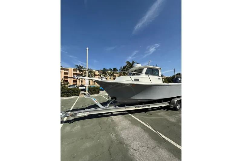  Yacht Photos Pics 2023 Parker 2320 Sport Cabin boat on trailer in parking lot.